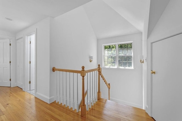 entryway featuring wood finished floors, lofted ceiling, and baseboards