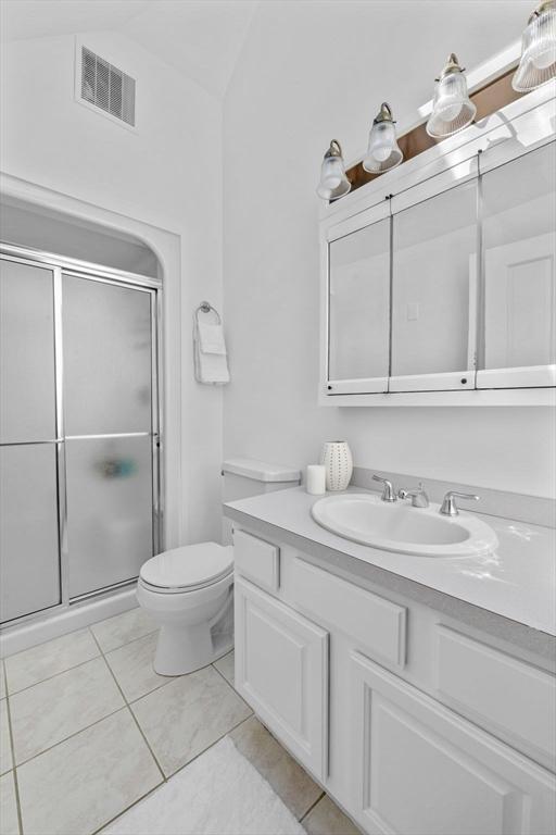 bathroom with a shower stall, toilet, and vanity