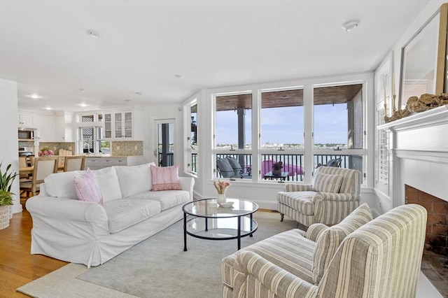 living area with plenty of natural light, a tile fireplace, light wood-type flooring, and recessed lighting
