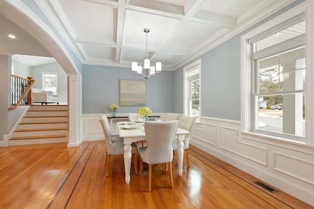 dining area with stairs, a wealth of natural light, beam ceiling, and visible vents