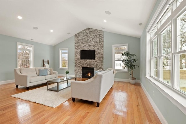 living room featuring a healthy amount of sunlight, light wood-style flooring, a fireplace, and baseboards