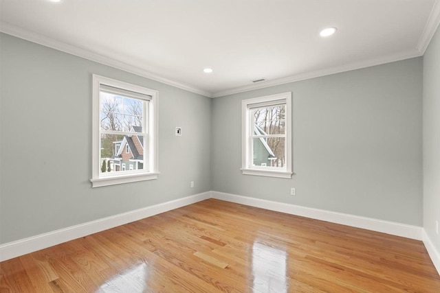 empty room with visible vents, baseboards, light wood-style flooring, crown molding, and recessed lighting