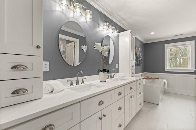 bathroom featuring a wainscoted wall, a freestanding bath, a sink, and crown molding