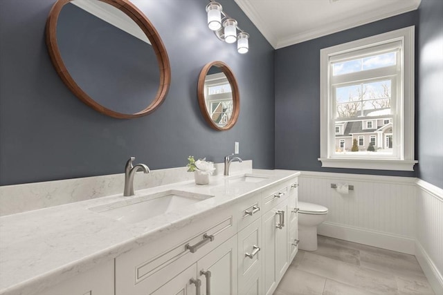 bathroom with a wainscoted wall, a sink, and toilet