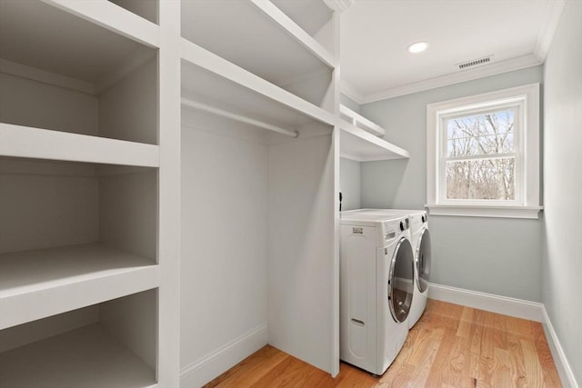 laundry room featuring baseboards, laundry area, light wood-type flooring, and washer and dryer