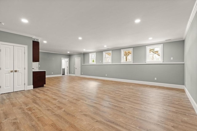 unfurnished living room with baseboards, ornamental molding, and light wood-style floors