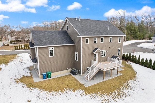 back of property with a shingled roof, stairway, a deck, and cooling unit