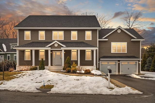 view of front of home featuring a garage, driveway, a porch, and roof with shingles