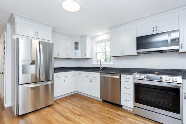 6 Post Gate Rd, Danvers, MA 01923 - kitchen featuring appliances with stainless steel finishes, white cabinets, light wood-style flooring, and a sink