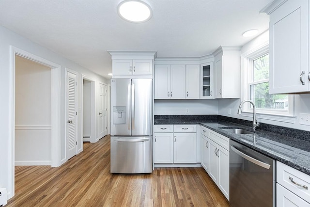 6 Post Gate Rd, Danvers, MA 01923 - kitchen featuring appliances with stainless steel finishes, a sink, white cabinets, dark stone counters, and wood finished floors