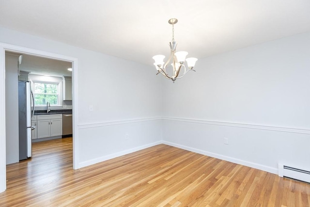 6 Post Gate Rd, Danvers, MA 01923 - empty room with a baseboard heating unit, light wood-type flooring, a chandelier, and baseboards