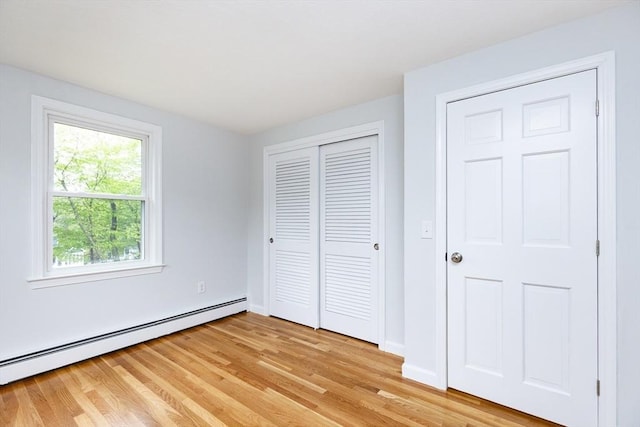 6 Post Gate Rd, Danvers, MA 01923 - unfurnished bedroom with a baseboard heating unit, light wood-style floors, a closet, and baseboards