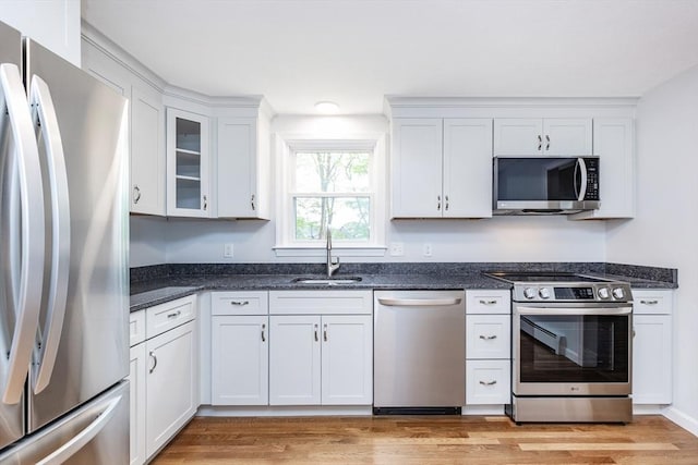 6 Post Gate Rd, Danvers, MA 01923 - kitchen with stainless steel appliances, a sink, white cabinets, light wood-style flooring, and glass insert cabinets