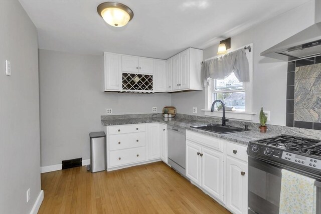 kitchen with wall chimney range hood, white cabinets, a sink, dishwasher, and black range with gas cooktop