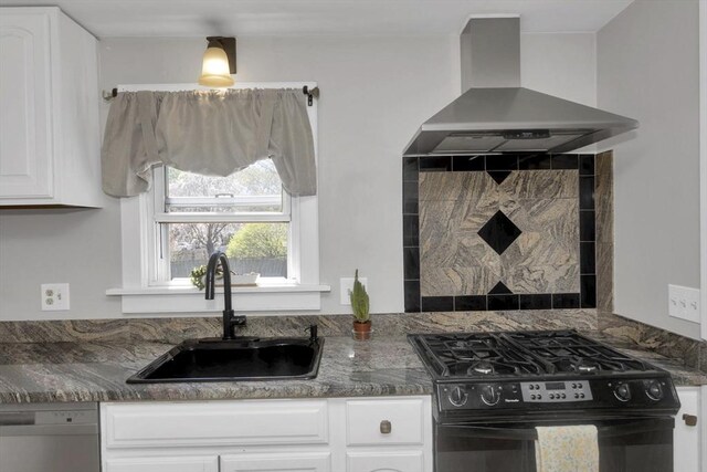 kitchen featuring white cabinets, black gas range oven, a sink, wall chimney exhaust hood, and dishwashing machine