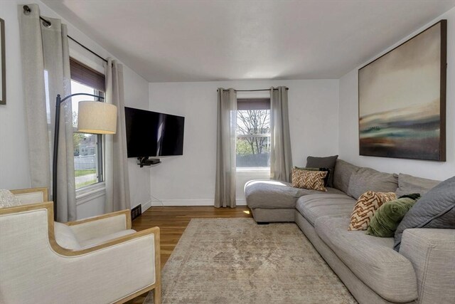living area with baseboards and wood finished floors