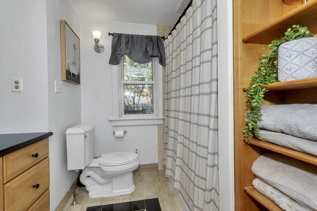 bathroom with vanity, toilet, baseboards, tile patterned floors, and a shower with curtain
