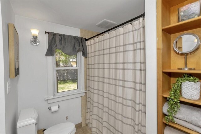 full bath with toilet and a shower with shower curtain