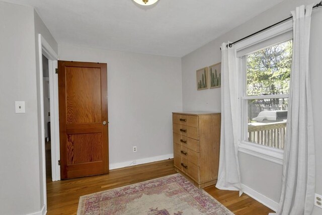 bedroom with baseboards and wood finished floors