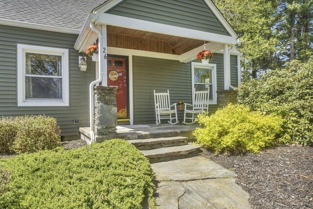 property entrance with a porch and a shingled roof
