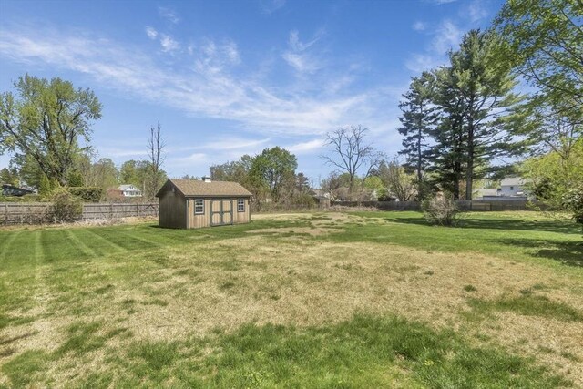 view of yard featuring an outbuilding, a fenced backyard, and a storage unit