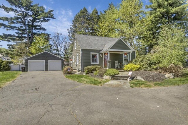 view of front of property featuring a garage, an outbuilding, and covered porch