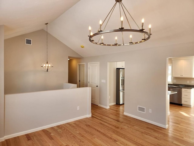 unfurnished room with lofted ceiling, light wood-style floors, visible vents, and a chandelier