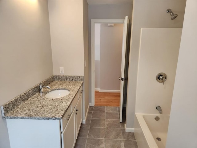 full bath featuring tub / shower combination, vanity, baseboards, and tile patterned floors