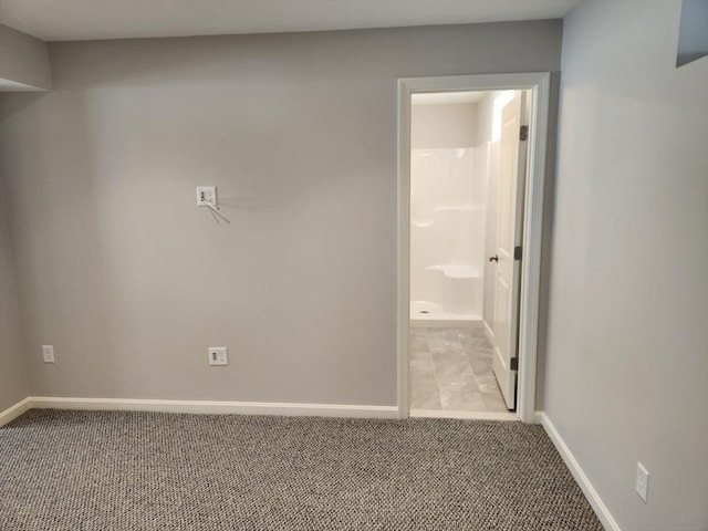 unfurnished bedroom with carpet floors, connected bathroom, and baseboards