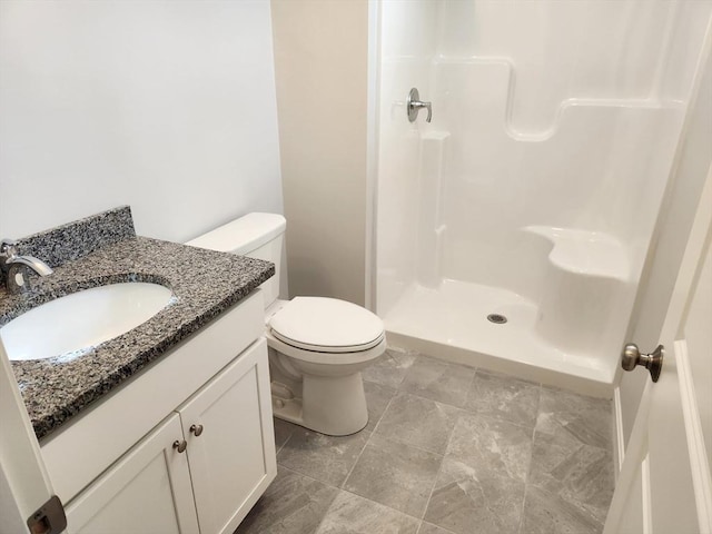 bathroom featuring a stall shower, vanity, and toilet