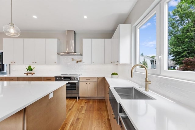 66 Upham St, Newton, MA 02465 - kitchen featuring wall chimney exhaust hood, electric range, tasteful backsplash, a sink, and decorative light fixtures