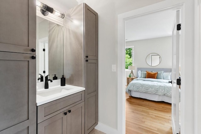 66 Upham St, Newton, MA 02465 - ensuite bathroom featuring vanity, wood finished floors, and baseboards