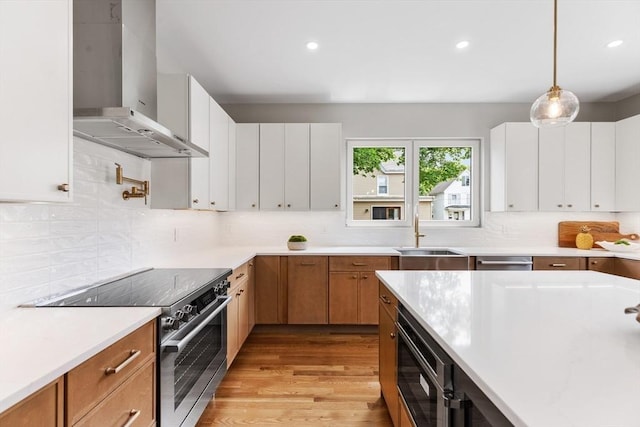 66 Upham St, Newton, MA 02465 - kitchen with wall chimney range hood, electric range, a sink, light wood finished floors, and light countertops