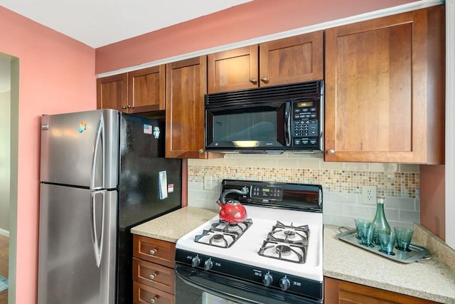 17 Angela Ln Unit 17, Watertown, MA 02472 - kitchen featuring black microwave, range with gas cooktop, freestanding refrigerator, brown cabinets, and decorative backsplash