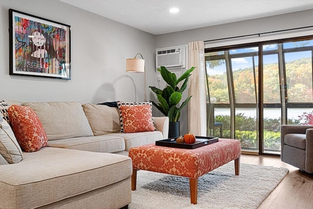 living room with wood-type flooring and an AC wall unit