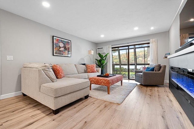 living room with light wood-type flooring and an AC wall unit