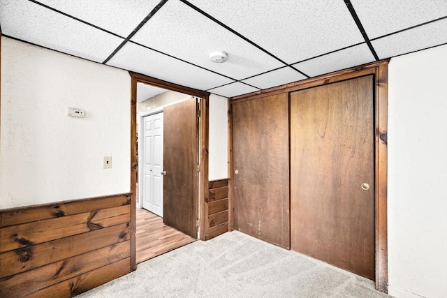 carpeted bedroom with a paneled ceiling and a closet