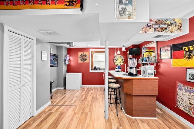 bar featuring hardwood / wood-style flooring and refrigerator