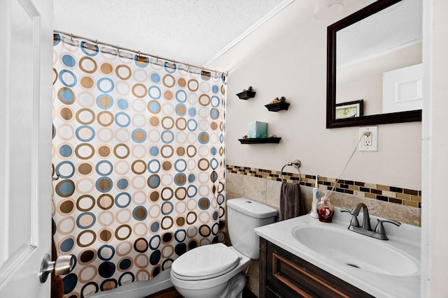 bathroom featuring tile walls, vanity, ornamental molding, toilet, and a textured ceiling