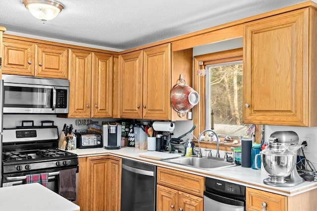 kitchen featuring sink, stainless steel appliances, and a textured ceiling