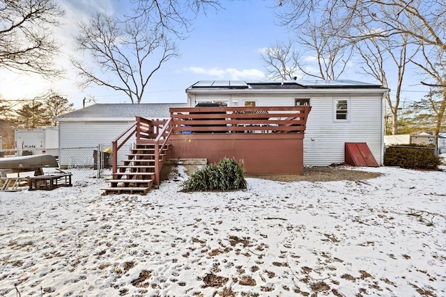 snow covered rear of property with a deck