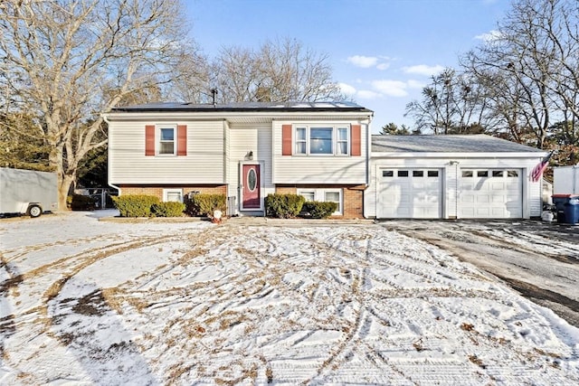 split foyer home with a garage and solar panels