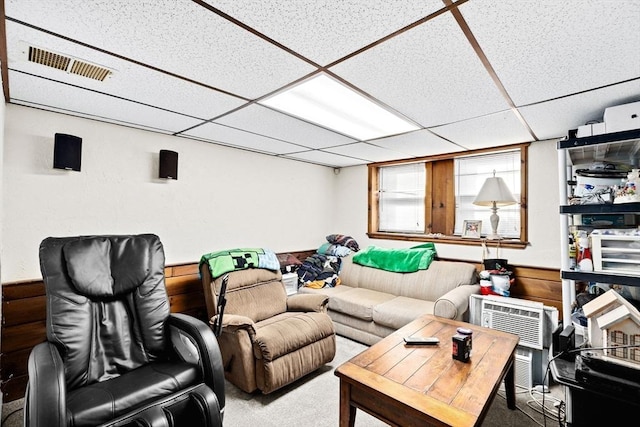 carpeted living room with a drop ceiling