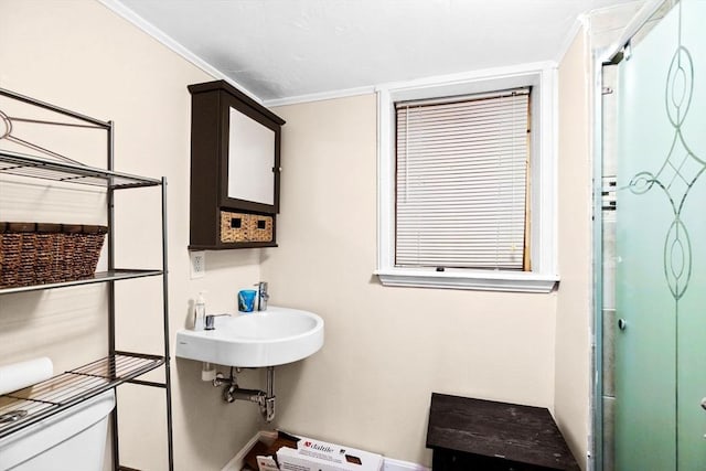 bathroom featuring sink, an enclosed shower, and toilet