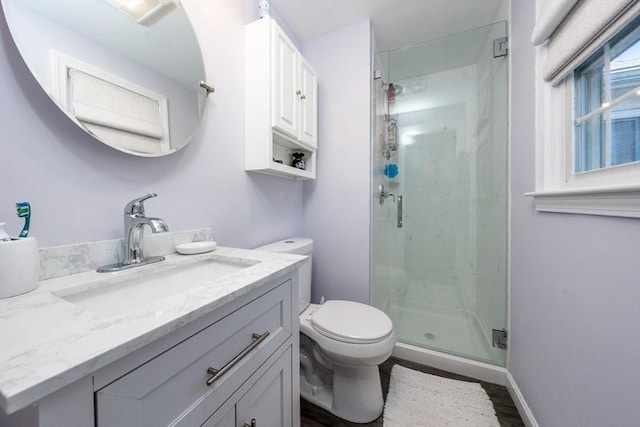 full bathroom featuring vanity, wood finished floors, baseboards, a shower stall, and toilet