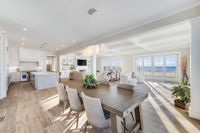 dining space with beamed ceiling, coffered ceiling, and light hardwood / wood-style flooring