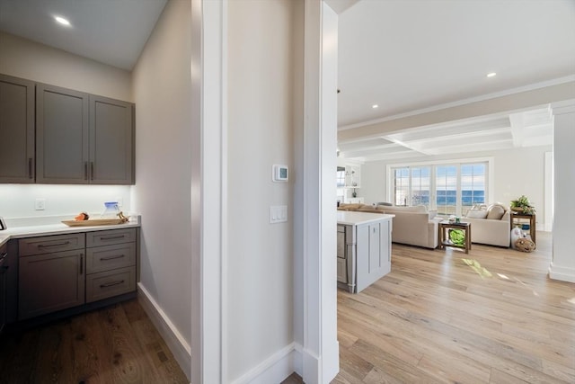 kitchen featuring gray cabinets, light hardwood / wood-style flooring, beam ceiling, and coffered ceiling