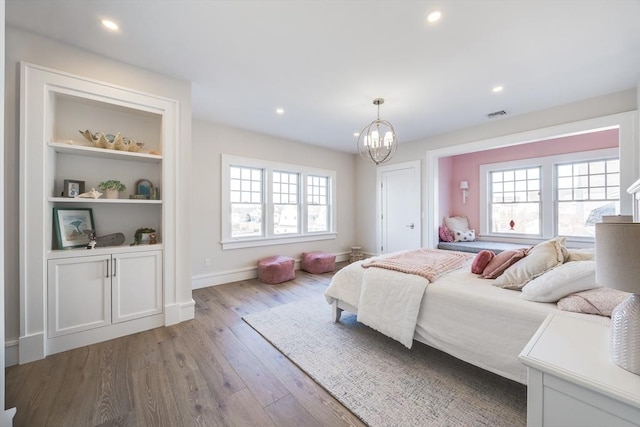 bedroom featuring light hardwood / wood-style floors and a notable chandelier