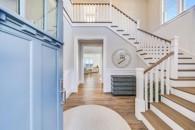 entryway with a towering ceiling and hardwood / wood-style floors