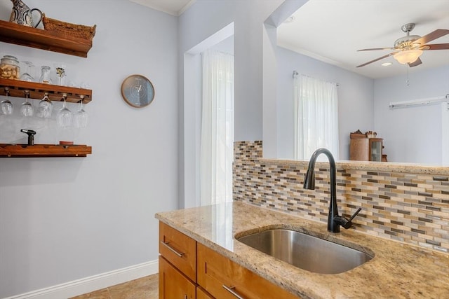 37 Devereux St, Marblehead, MA 01945 - kitchen featuring backsplash, light stone countertops, a ceiling fan, crown molding, and brown cabinets